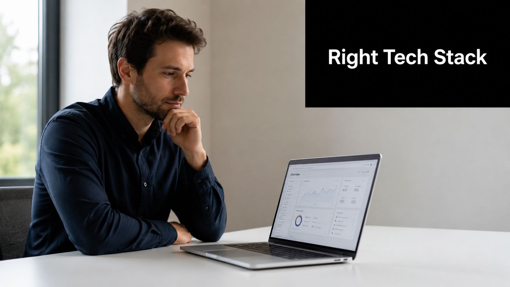 A professional man sitting at a desk and reviewing business analytics on his laptop computer screen.