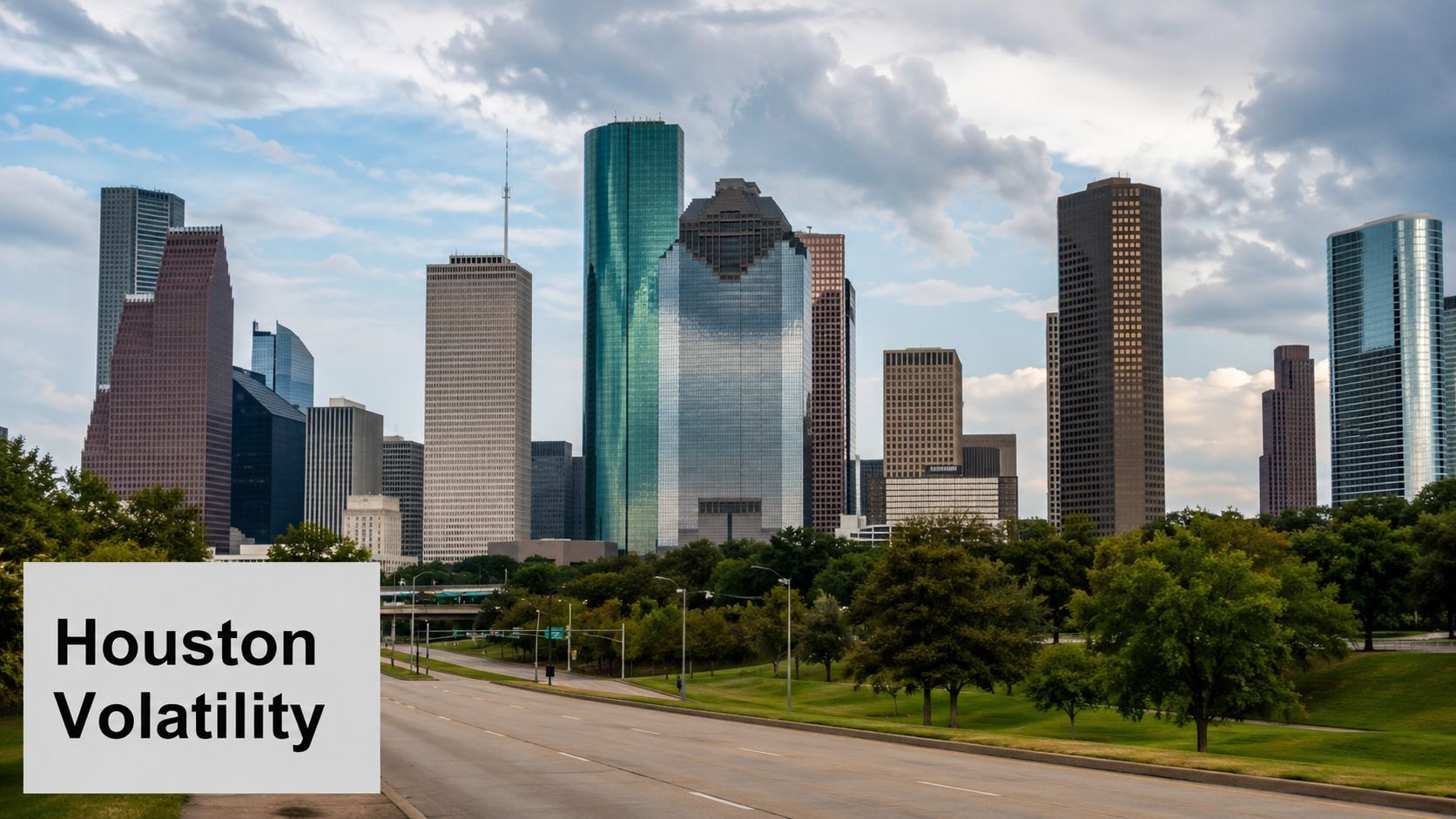 A wide angle view of the Houston skyline featuring iconic glass skyscrapers above a grassy park