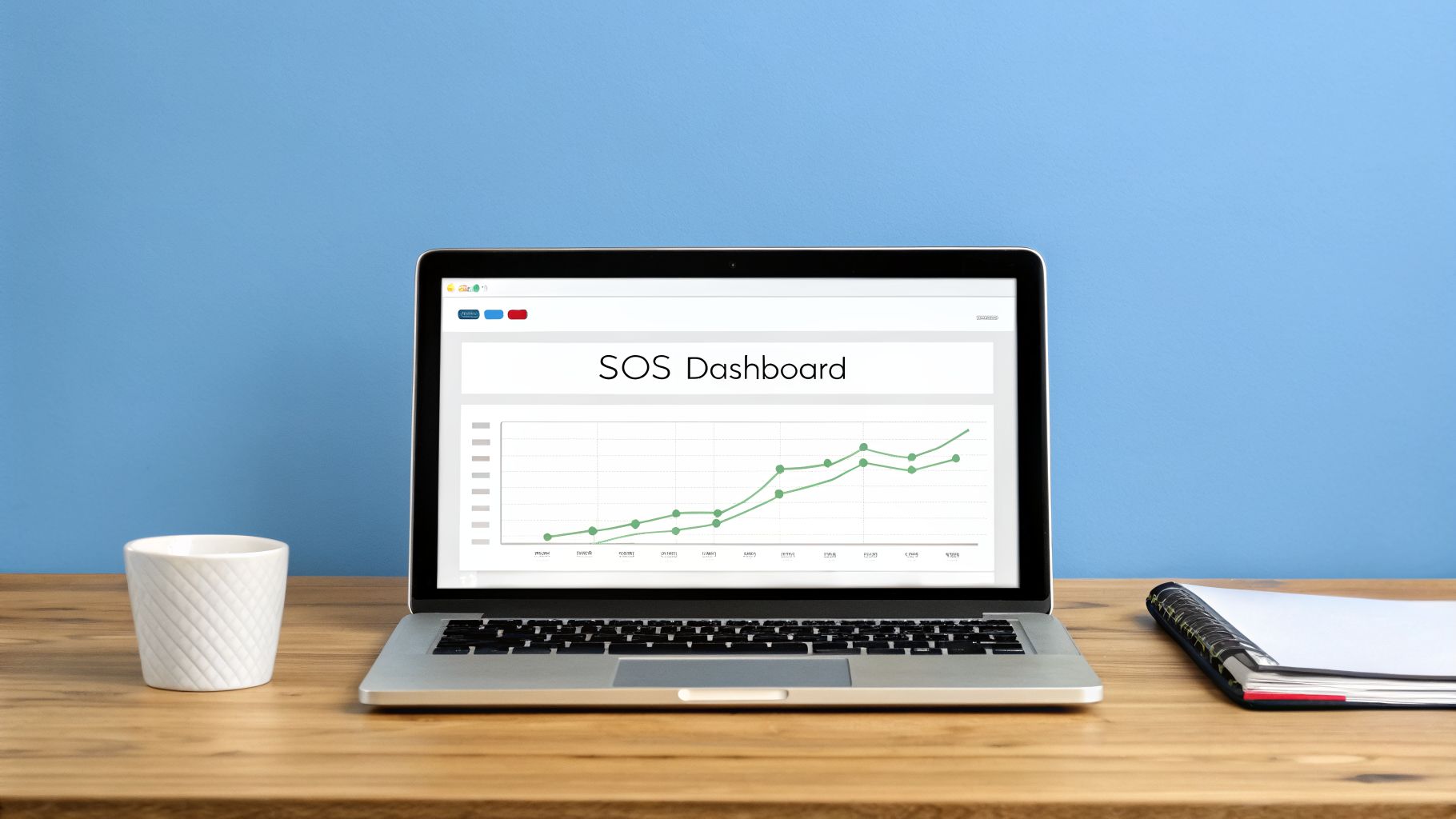 Laptop displaying an SOS Dashboard with a green line graph, a white cup, and a notebook on a wooden desk.
